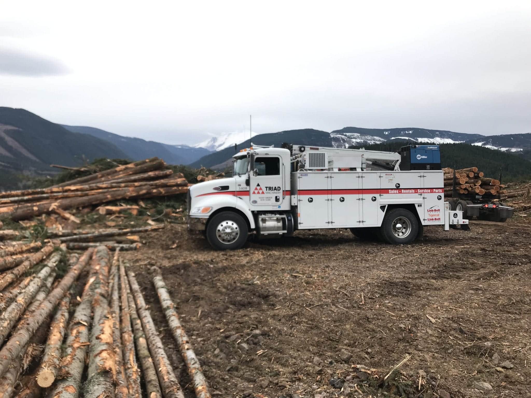 a Triad Machinery forestry field service technician truck at a logging site.